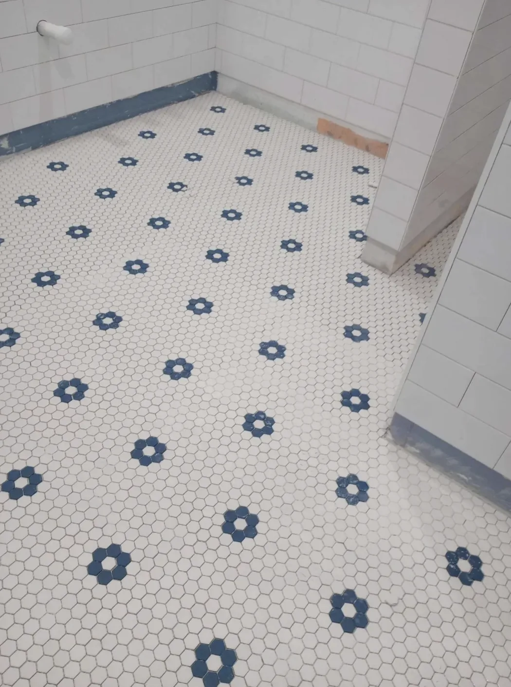 White hexagon mosaic floor tile with a blue flower pattern