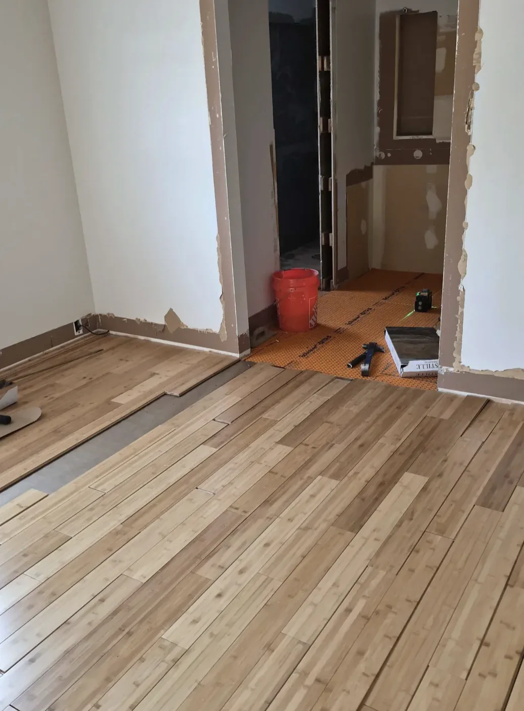 Light wood plank flooring being installed toward a doorway