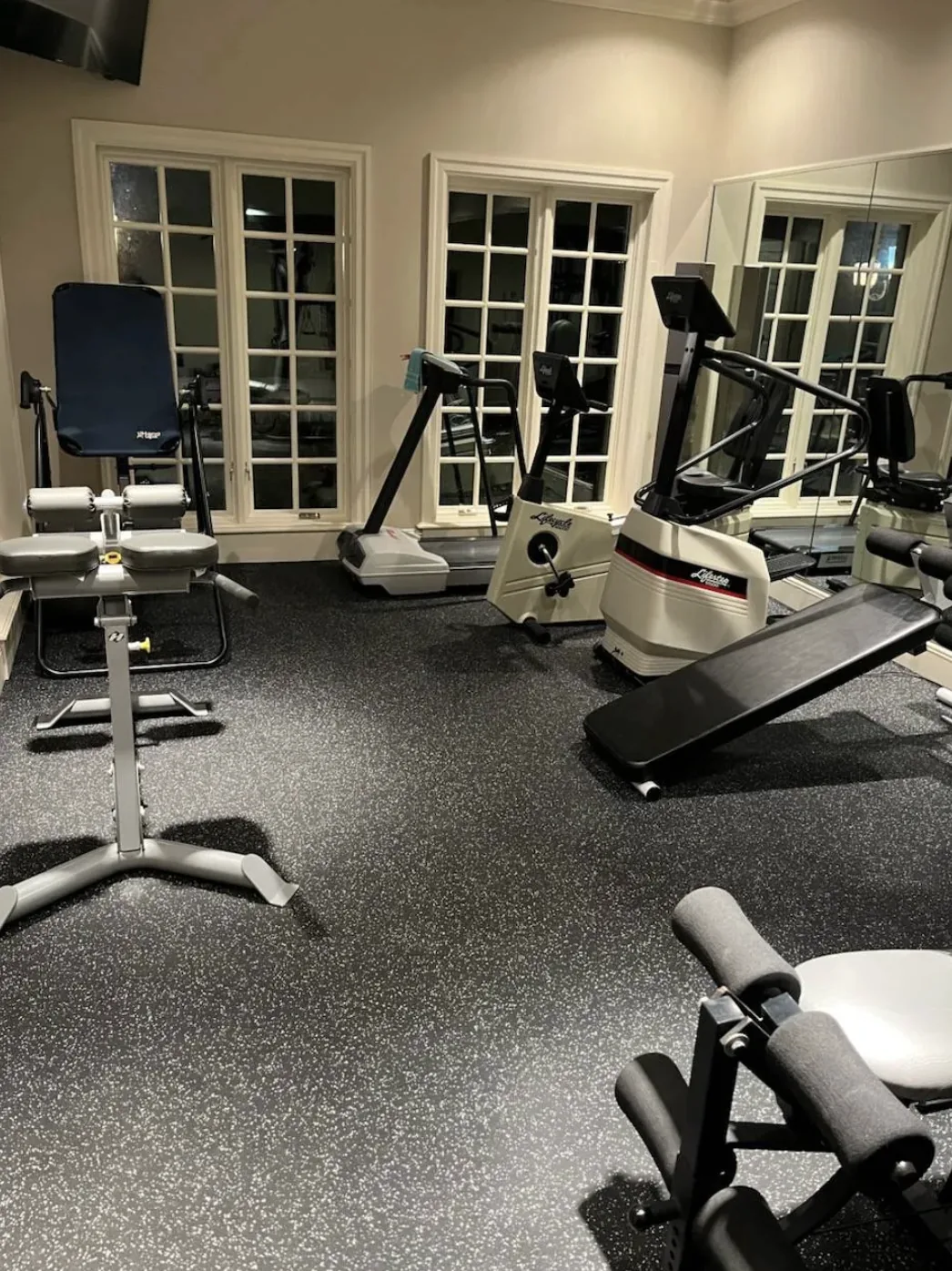 Home gym with speckled rubber gym mat flooring and exercise equipment