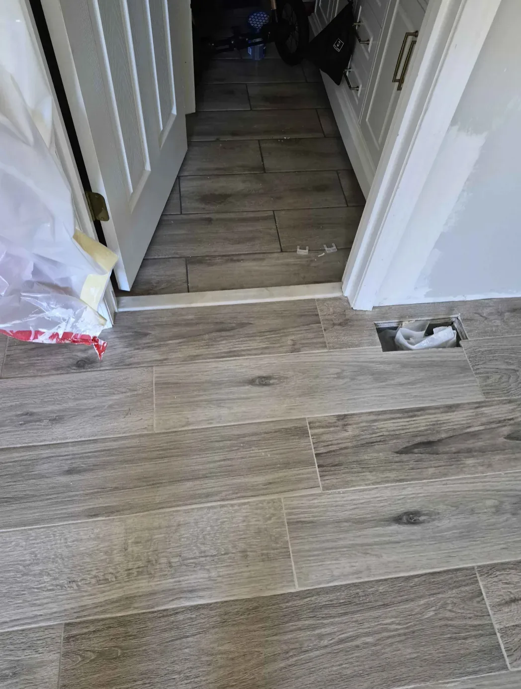 Gray wood-look plank floor running through a doorway