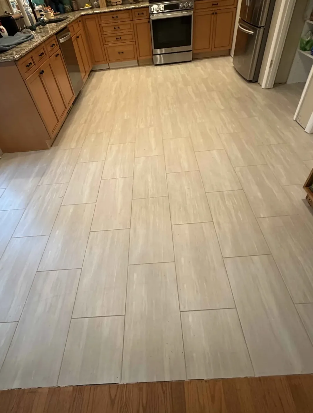 Light wood-look plank flooring in a kitchen with oak cabinets